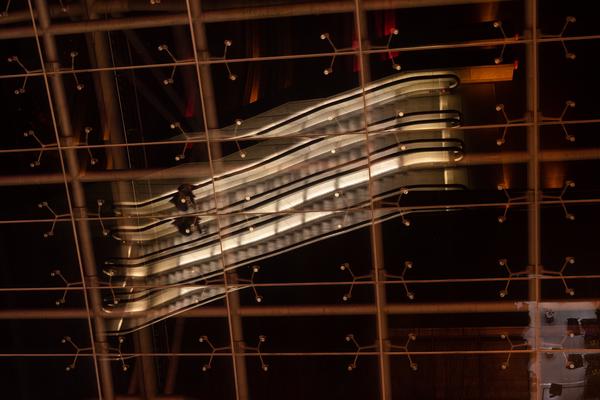 Escalators reflected in glass ceiling